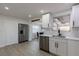 Modern kitchen with stainless steel appliances, white cabinets, white subway tile and a view into the dining room at 1313 Pine Ridge Dr, Daytona Beach, FL 32117