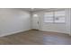 Bright living room with wood-look floors, a fresh coat of paint and natural light coming in from a large window at 1313 Pine Ridge Dr, Daytona Beach, FL 32117