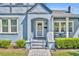 Close up of charming light blue bungalow with a brick pathway leading to the front door at 1413 W Harvard St, Orlando, FL 32804