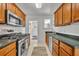 Galley kitchen features wood cabinets, stainless steel appliances, and a gas range at 1413 W Harvard St, Orlando, FL 32804