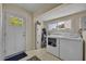 Functional laundry area featuring white washer and dryer, built-in storage, and access to the exterior at 1413 W Harvard St, Orlando, FL 32804