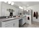 Bright bathroom featuring double sinks with gray countertops, a glass-enclosed shower, and white cabinets at 15186 Book Club Rd, Winter Garden, FL 34787
