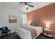 Cozy bedroom with coral accent wall, natural lighting, and comfortable bed at 15186 Book Club Rd, Winter Garden, FL 34787