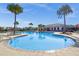 A large community pool with palm trees, lounge chairs, and nearby clubhouse for social gatherings at 15186 Book Club Rd, Winter Garden, FL 34787