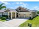Inviting single-Gathering home with a covered porch and a two-car garage, surrounded by green grass at 15186 Book Club Rd, Winter Garden, FL 34787