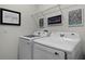 Neat laundry room featuring modern washer and dryer units with framed artwork on the walls at 15186 Book Club Rd, Winter Garden, FL 34787