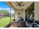 Inviting screened patio boasts ceiling fan and picturesque views of lush backyard with a barbecue grill for outdoor entertaining at 15186 Book Club Rd, Winter Garden, FL 34787