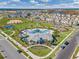 Aerial view of the community pool and clubhouse, with palm trees, playground, and a basketball court at 15186 Book Club Rd, Winter Garden, FL 34787