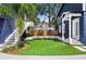 Backyard showcasing artificial grass, outdoor seating with umbrellas, and access stairs to an upper level at 1521 E Harwood St, Orlando, FL 32803