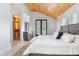 Bright bedroom with wood ceiling, closet, black french doors and white bedding at 1521 E Harwood St, Orlando, FL 32803