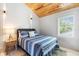 Comfortable bedroom boasts shuttered windows, a blue-striped bedspread and modern lighting at 1521 E Harwood St, Orlando, FL 32803