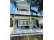 Charming two-story home with a covered front porch featuring white rocking chairs and decorative tile accents at 1521 E Harwood St, Orlando, FL 32803
