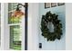Close-up of a light blue front door with a wreath, stylish exterior light, and a keypad lock at 1521 E Harwood St, Orlando, FL 32803