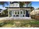 Inviting front porch with white rocking chairs, decorative tile, and a charming light blue front door at 1521 E Harwood St, Orlando, FL 32803