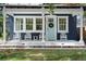 Welcoming front porch featuring white rocking chairs, decorative tile, and a charming light blue front door at 1521 E Harwood St, Orlando, FL 32803