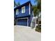 Stylish two-story home with a blue garage door and exterior staircase leading to the upper level at 1521 E Harwood St, Orlando, FL 32803