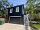 Two-story home featuring a dark blue garage door and exterior staircase with palm tree at 1521 E Harwood St, Orlando, FL 32803