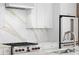 Modern kitchen showcasing white cabinets, stainless steel appliances, and white marble countertops at 1521 E Harwood St, Orlando, FL 32803