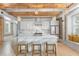 Modern white kitchen with marble countertops, stainless steel appliances, and island with seating at 1521 E Harwood St, Orlando, FL 32803
