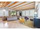 Bright living room with wood beam ceiling, herringbone floors, and stylish, colorful furniture at 1521 E Harwood St, Orlando, FL 32803