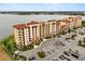 Scenic aerial view of condominiums with a spacious parking lot and a serene lake backdrop at 16300 County Road 455 # 204, Montverde, FL 34756