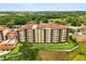 Aerial view of a yellow condominium complex amidst lush green surroundings at 16300 County Road 455 # 204, Montverde, FL 34756