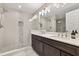 Modern bathroom featuring dual sinks, a walk-in shower with decorative tile, and stylish lighting at 16300 County Road 455 # 204, Montverde, FL 34756