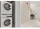 Hallway with a stacked washer and dryer, console table and view of the front door at 16300 County Road 455 # 204, Montverde, FL 34756