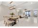 Open-concept living and dining area featuring elegant lighting fixtures and a sliding glass door to the balcony at 16300 County Road 455 # 204, Montverde, FL 34756