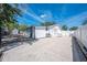 Wide-angle view of concrete patio with a hammock, basketball hoop, storage shed and a freshly painted white fence at 194 Larkspur Ct, Kissimmee, FL 34743