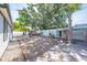 Backyard area features a rock garden, a chicken coop, a barbecue, and a small storage shed at 194 Larkspur Ct, Kissimmee, FL 34743