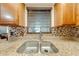 Close up of kitchen sink with granite countertops and mosaic backsplash, illuminated by natural light at 194 Larkspur Ct, Kissimmee, FL 34743