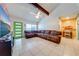 Open-concept living room with a large sectional sofa, exposed beam, and modern finishes at 194 Larkspur Ct, Kissimmee, FL 34743