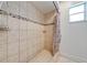 Tiled shower stall with a decorative tile strip and shower curtain at 194 Larkspur Ct, Kissimmee, FL 34743