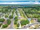 Overhead shot of a charming home surrounded by lush trees in a peaceful neighborhood under a partly cloudy sky at 1961 Lochshyre Loop, Ocoee, FL 34761