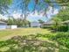 Expansive backyard with lush lawn, mature trees, and a view of a charming single-story home on a sunny day at 1961 Lochshyre Loop, Ocoee, FL 34761