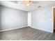 Spacious bedroom with wood-look flooring, neutral walls, ceiling fan, and a white interior door to a closet at 1961 Lochshyre Loop, Ocoee, FL 34761