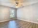 Cozy bedroom featuring wood-look flooring, neutral paint, a ceiling fan, and view to the exterior at 1961 Lochshyre Loop, Ocoee, FL 34761