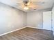 Bedroom with wood-look flooring, ceiling fan, neutral paint, and white trim at 1961 Lochshyre Loop, Ocoee, FL 34761
