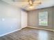 Bedroom with wood-look flooring, ceiling fan, and a double door closet at 1961 Lochshyre Loop, Ocoee, FL 34761