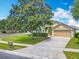 Charming single-story home featuring a well-manicured lawn, mature tree, and a two-car garage at 1961 Lochshyre Loop, Ocoee, FL 34761