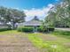 Well-maintained front lawn featuring a quaint single-story home with neat landscaping and mature trees on a sunny day at 1961 Lochshyre Loop, Ocoee, FL 34761