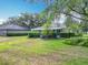 Beautiful front yard with lush lawn and mature landscaping surrounding a charming single-story home under a bright blue sky at 1961 Lochshyre Loop, Ocoee, FL 34761
