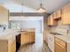Open kitchen with wood cabinets, laminate floor, and black appliances at 1961 Lochshyre Loop, Ocoee, FL 34761