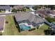 Home with screened pool enclosure features a lush lawn, providing an ideal setting for outdoor enjoyment at 212 Terranova Blvd, Winter Haven, FL 33884