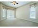 Bright bedroom with carpet, ceiling fan, large windows, and access to the outdoors at 212 Terranova Blvd, Winter Haven, FL 33884