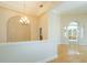 Open dining room featuring hardwood floors, arched entryway, and chandelier lighting at 212 Terranova Blvd, Winter Haven, FL 33884