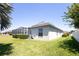 Exterior view of the home featuring a screened in pool and lush green grass at 212 Terranova Blvd, Winter Haven, FL 33884