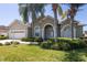 Charming single-story home boasts mature landscaping, an arched entryway, and a two-car garage at 212 Terranova Blvd, Winter Haven, FL 33884