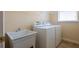 Laundry room featuring a utility sink, washer, and dryer at 212 Terranova Blvd, Winter Haven, FL 33884